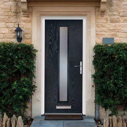 Black composite door with decorative glass panel on a stone building facade.
